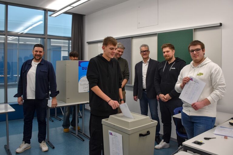 Anlässlich der bevorstehenden Bundestagswahl hat Jugendreferent Thomas Heidecker (l.) zusammen mit dem Feuchtwanger Jugendbeirat, vertreten durch Fabian Pröger (r.), und der Mittelschule Feuchtwangen-Land eine U18-Wahl organisiert. Während in der Wahlkabine Muhittin Nouri Oglou aus der Klasse 9aM (2.v.l.) noch sein Kreuz setzt, wirft Mitschüler Diego Sahm (3.v.l.) seinen bereits gekennzeichneten Stimmzettel in die Wahlurne. Die Relevanz der Wahlsimulation betonten Bürgermeister Patrick Ruh (3.v.r.), Schulleiter Johannes Stegmann (4.v.r.) und Fabian Pöppl, Leiter der Klasse 9aM.