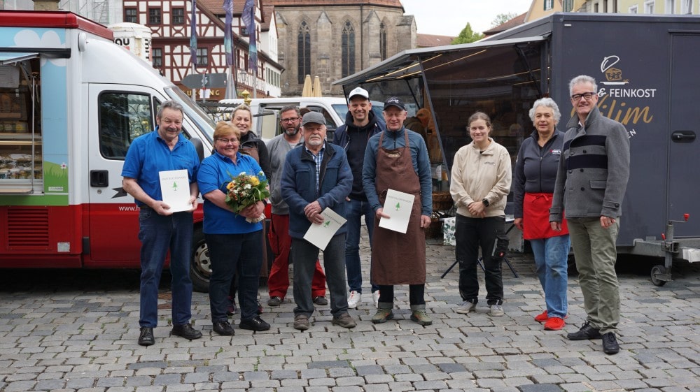 Ehrungen am Feuchtwanger Wochenmarkt: Werner und Erika Just und Gerhard Emmert wurden jeweils für ihr 30-jähriges Jubiläum ausgezeichnet, daneben Oliver Vilim für sein 25-jähriges Jubiläum (1. Reihe von links). Zum Jubiläum gratulierten 1. Bürgermeister Patrick Ruh (rechts) und auch alle weiteren Feuchtwanger Markthändler (2. Reihe).