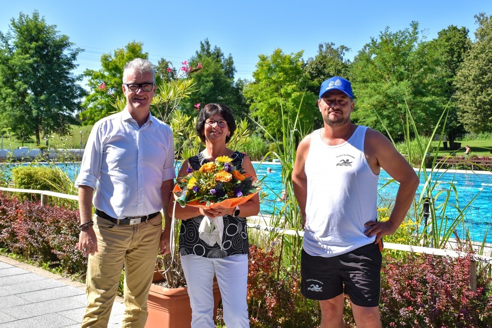 Als 25.000. Badegast der laufenden Saison im Feuchtwanger Freibad erhielt Karin Hirsch (Mitte) einen Blumenstrauß und einen Gutschein für eine Freibad-Saisonkarte von Feuchtwangens ersten Bürgermeister Patrick Ruh (links) und Freibadleiter Heiko Hercher.