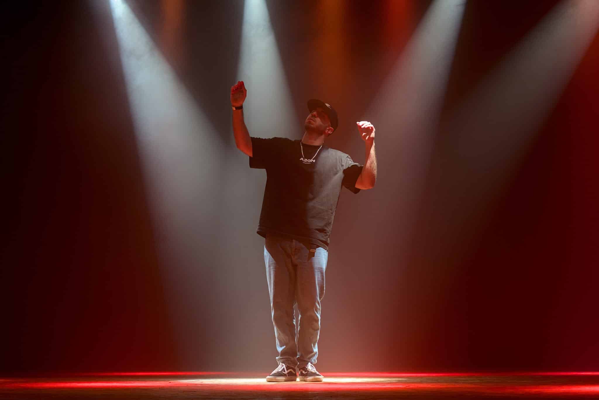 Ein Tänzer im roten Scheinwerferlicht auf der Bühne in der Stadthalle Kasten.